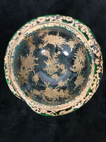 A round glass bowl decorated with gold inclusions...