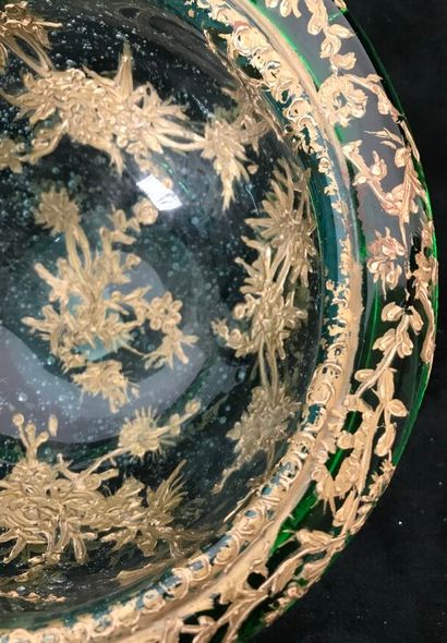 A round glass bowl decorated with gold inclusions...