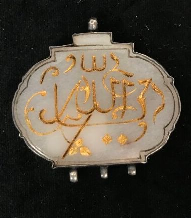 A white nephrite oval pendant engraved with...