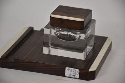 Glass inkwell resting on a macassar ebony...
