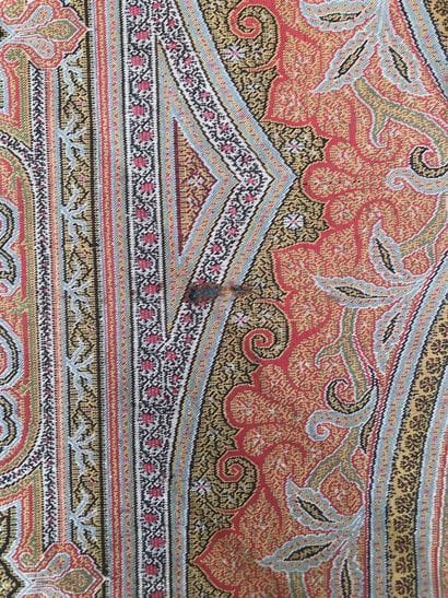 A fringed fabric with paisley on a red background
Height...