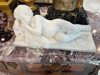 White marble sculpture of a reclining putto...