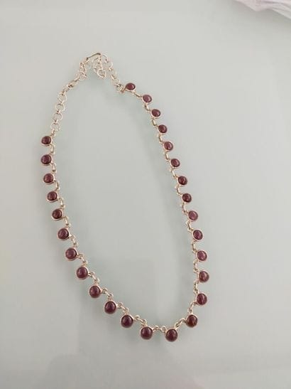 Silver necklace adorned with garnet cabochon...