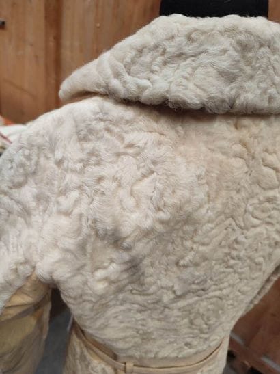 CARVEN
Mid-length, belted coat in cream astrakhan...