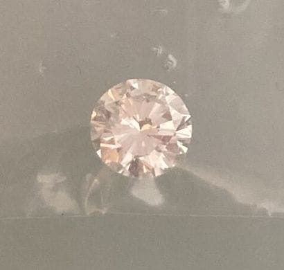 Round brilliant-cut diamond on paper.
Accompanied...