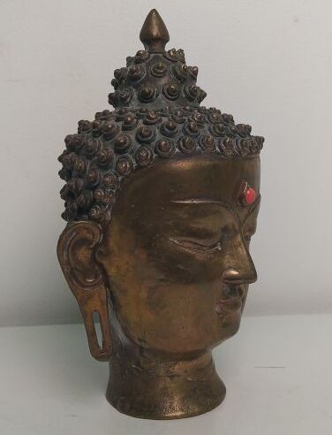 Gilded bronze Buddha head, adorned with an...