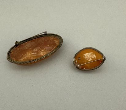Set of two brooches, one in metal, the other...
