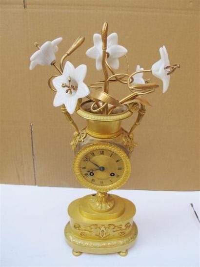 Pendule vase en bronze ciselé et doré. Le...