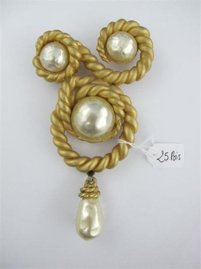 CHANEL
Importante broche en métal doré orné...