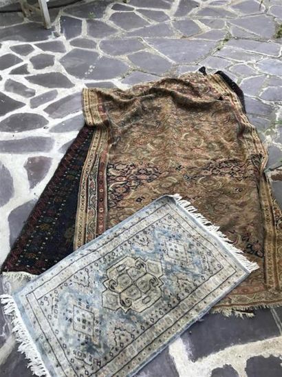 Trois tapis usagés.