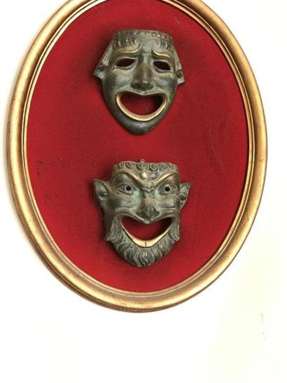 Deux masques en bronze dans un cadre ova...