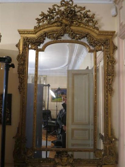 Grand miroir en bois et stuc doré à décor...