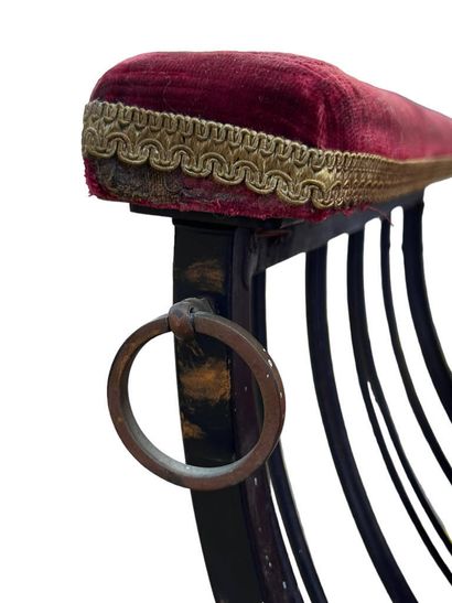 Two wrought-iron curved stools with crimson...