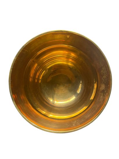 Gilded metal bowl on pedestal featuring a...