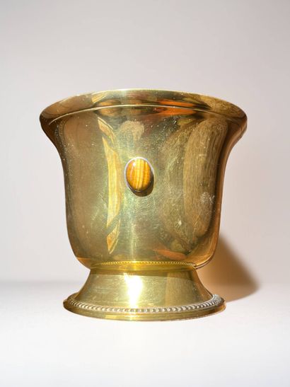 Gilded metal bowl on pedestal featuring a...