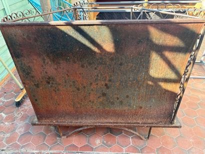 Gilded wrought-iron bar cabinet opening to...