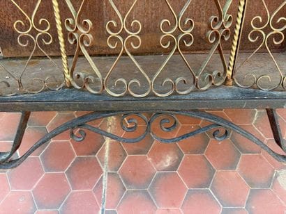 Gilded wrought-iron bar cabinet opening to...