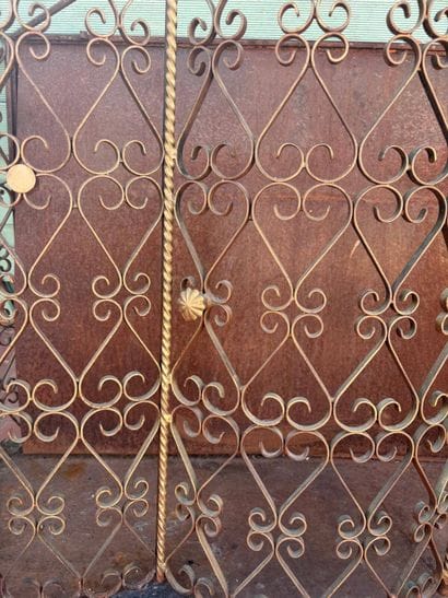 Gilded wrought-iron bar cabinet opening to...