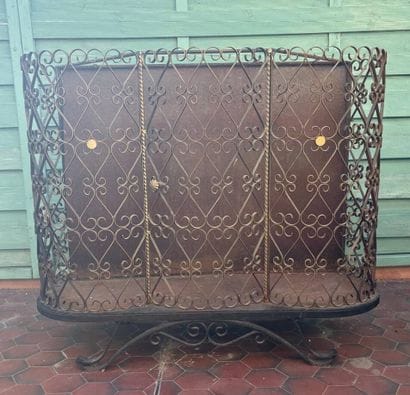 Gilded wrought-iron bar cabinet opening to...