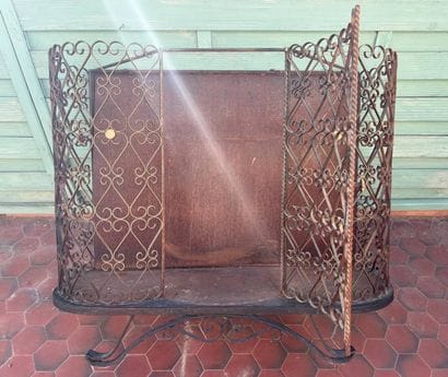Gilded wrought-iron bar cabinet opening to...