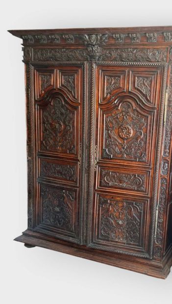 Carved walnut armoire opening on two doors,...