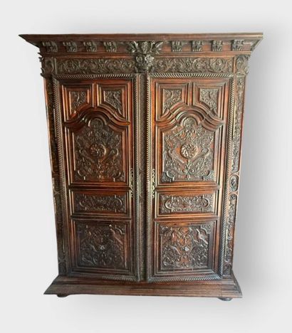 Carved walnut armoire opening on two doors,...