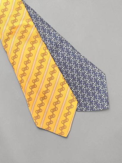 HERMÈS
Set of two printed silk ties, one...