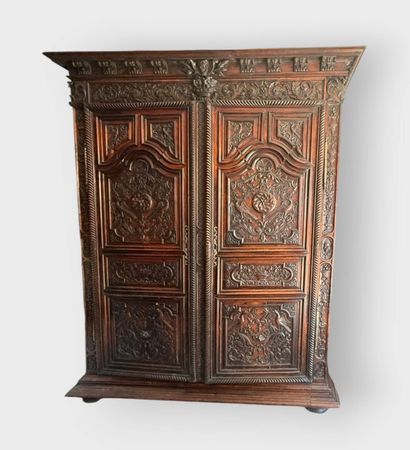 Carved walnut armoire opening on two doors,...