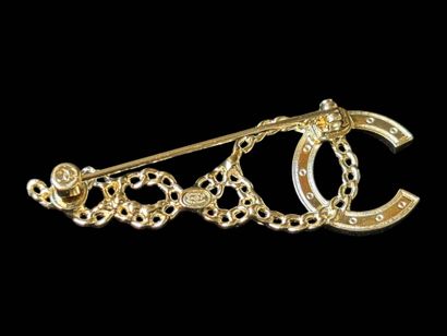 CHANEL
Brooch in gilt metal and white rhinestones...
