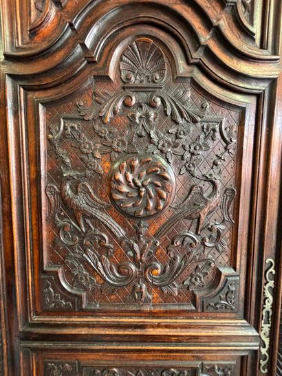 Carved walnut armoire opening on two doors,...