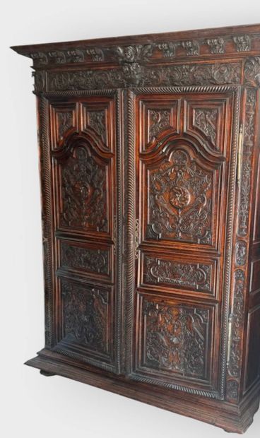 Carved walnut armoire opening on two doors,...