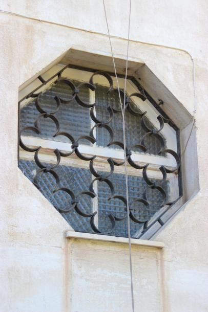 Une grille de fenêtre en fer forgé de forme...