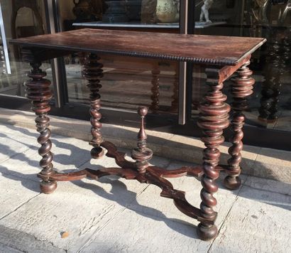 Table en bois naturel reposant sur quatre...