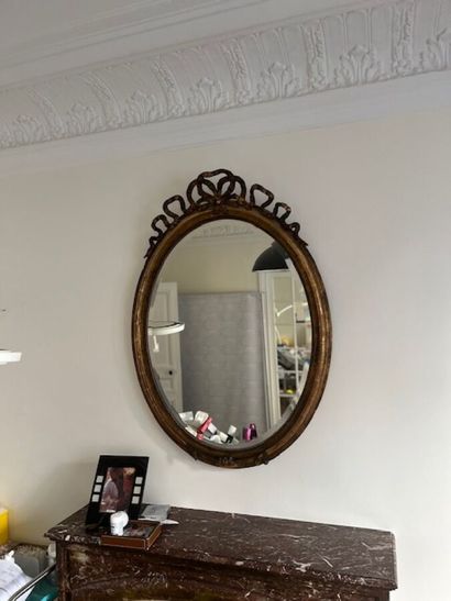 Miroir en bois et stuc doré de forme ovale,
Style...