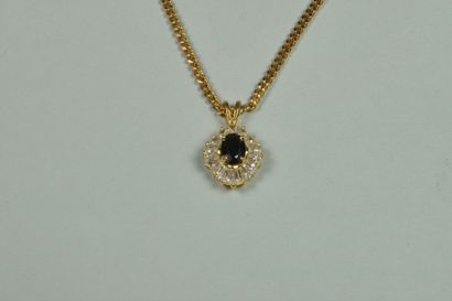 Chaîne en métal doré retenant un pendentif...