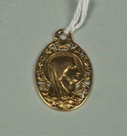 Médaille ovale en or jaune 18K (750/oo) représentant...