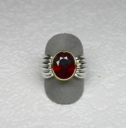 Bague bicolore soutenant en clos un rubis...