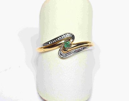 Bague bicolore centrée d'une émeraude ronde....