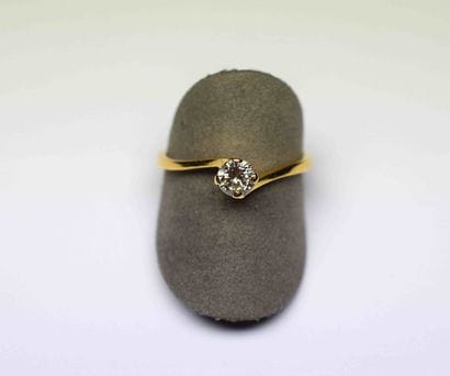 A yellow gold solitaire set with a diamond...
