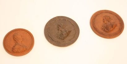 TROIS MEDAILLONS EN TERRE CUITE

Représentant...
