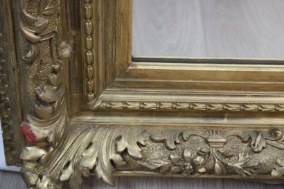 Miroir en bois doré à décor de rinceaux et...