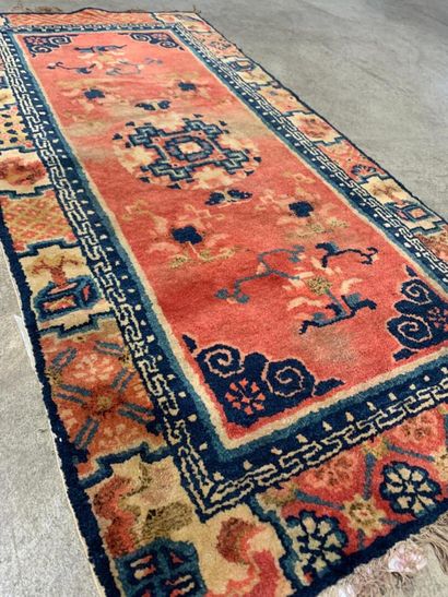 Carpet
Salmon-pink field decorated with geometrically...