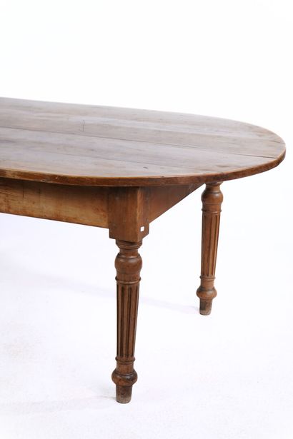 Rare table en noyer à plateau ovale à piètement...