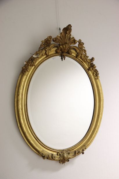 Miroir ovale en bois stuqué et doré de style...