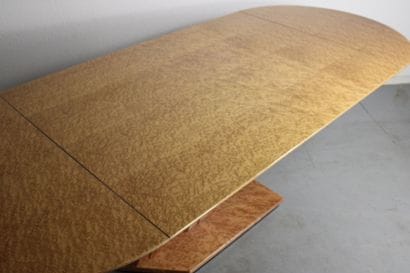 Dining table with oval top resting on a double...