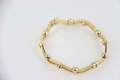 1 rigid gold bracelet, faceted balls. Gross...