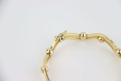 1 rigid gold bracelet, faceted balls. Gross...