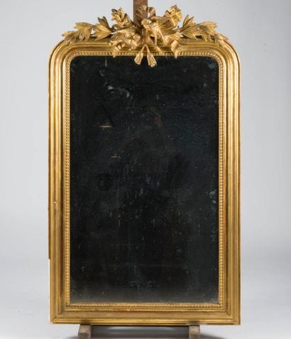 Miroir en bois et stuc doré orné d'un fronton...