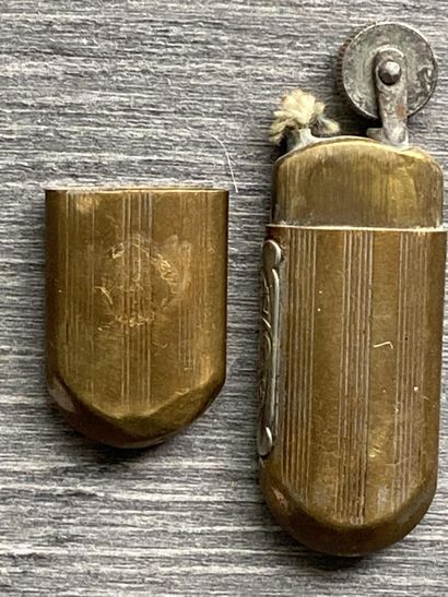 Un briquet en métal doré avec l'inscription...