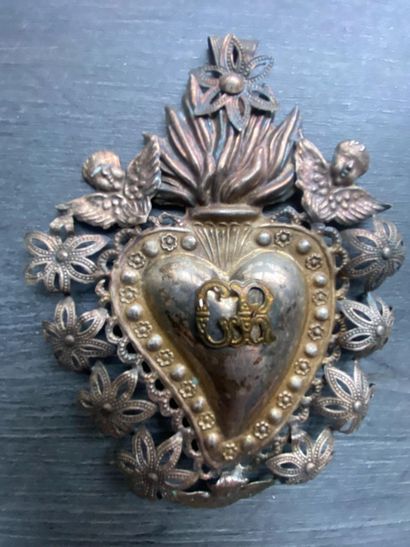 Un écusson en métal détouré en forme de coeur...